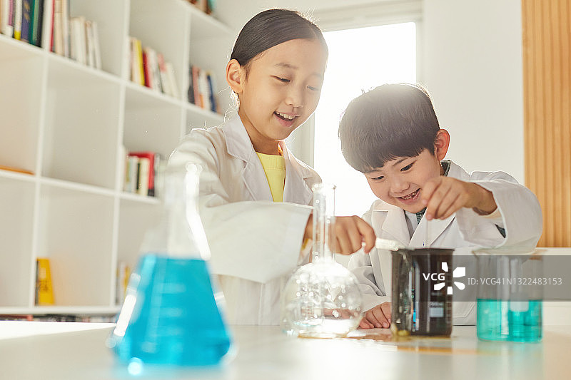 一个女孩和一个男孩在做科学实验图片素材