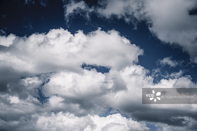 深蓝色的天空中出现了戏剧性的积云图片素材