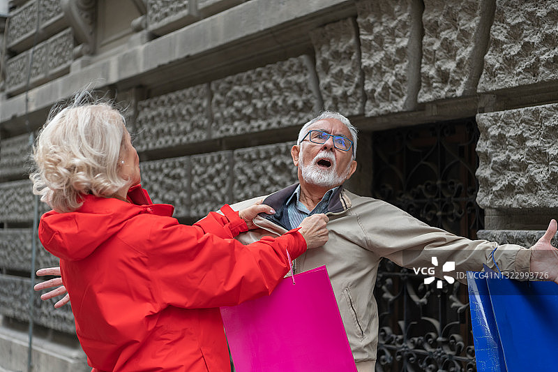 在市中心散步时，一位老人正在和他的妻子争吵。图片素材