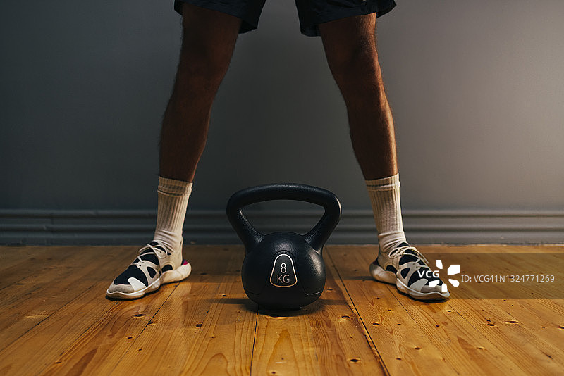 一个不知名的运动员用壶铃重量练习的腿图片素材