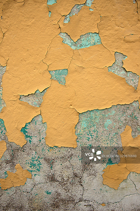 混凝土灰泥墙上的黄色油漆剥落图片素材
