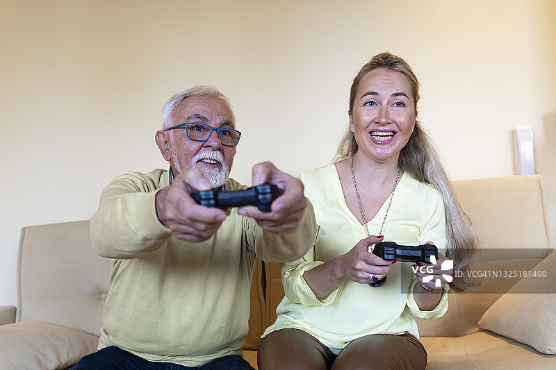 一个快乐的老人与他可爱的成熟的女儿玩灰头发和胡子。图片素材