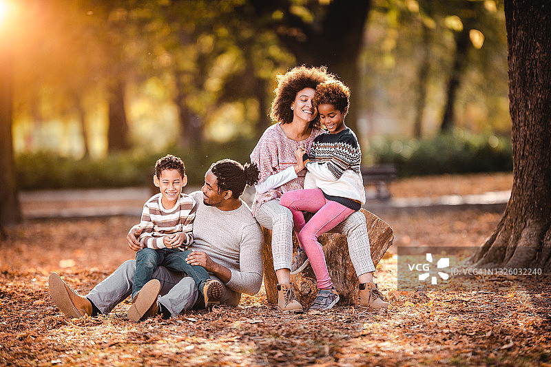 快乐的非裔美国家庭在公园享受秋天的一天。图片素材