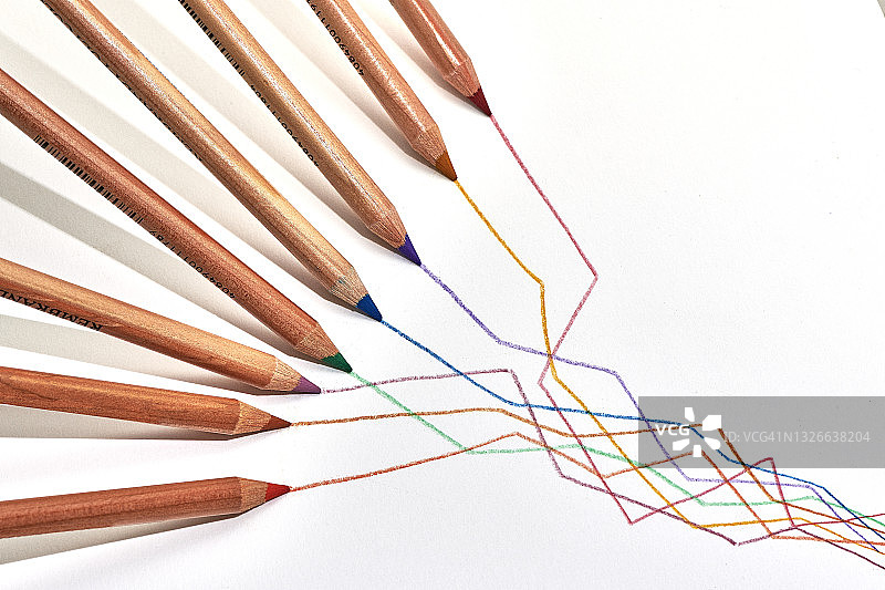 八支不同颜色的铅笔在白纸背景上画出纵横交错的线。图片素材