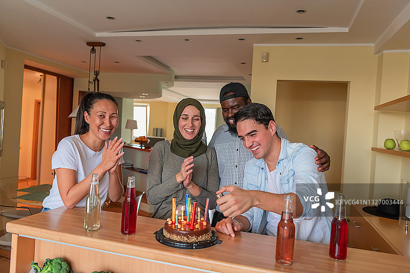 一个年轻人和一群来自不同种族的朋友一起过生日。图片素材