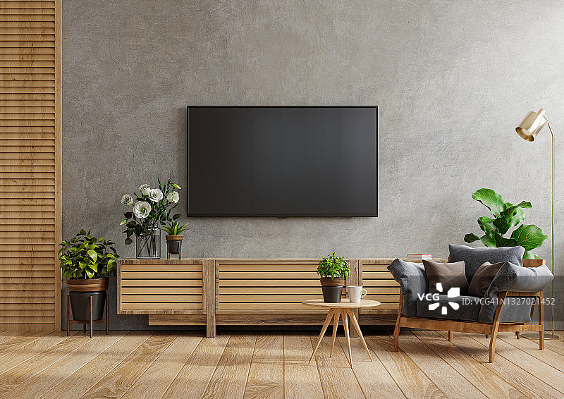 模拟电视墙安装在一个水泥房间扶手椅和桌子。图片素材
