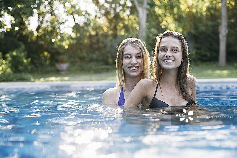 微笑的女人有乐趣在游泳池度假图片素材