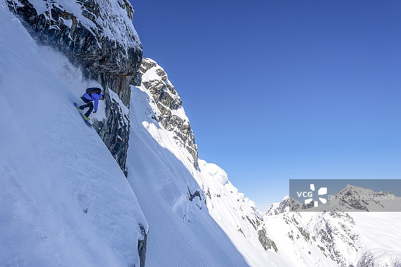 穷乡僻岭滑雪者下降雪山悬崖图片素材