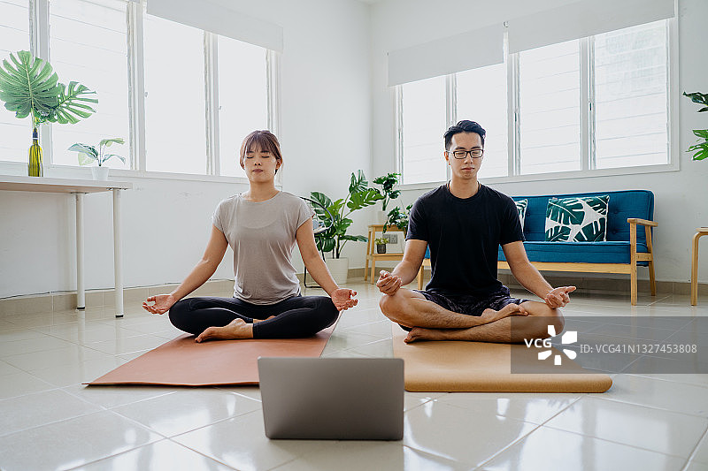 一对亚洲夫妇在家上在线瑜伽课图片素材