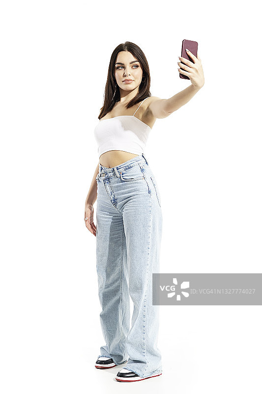 自信又时髦的Z一代年轻女性用智能手机自拍图片素材