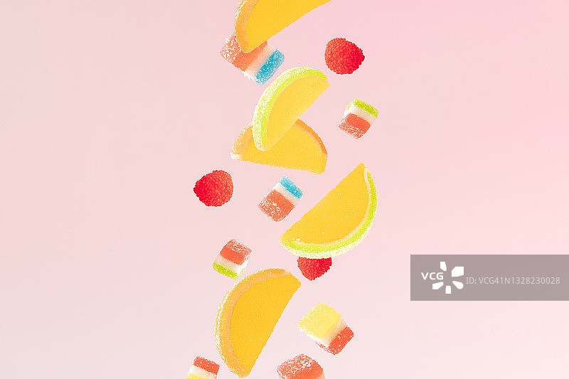 五颜六色的果冻落糖。粉红色的背景。最小的设计。图片素材