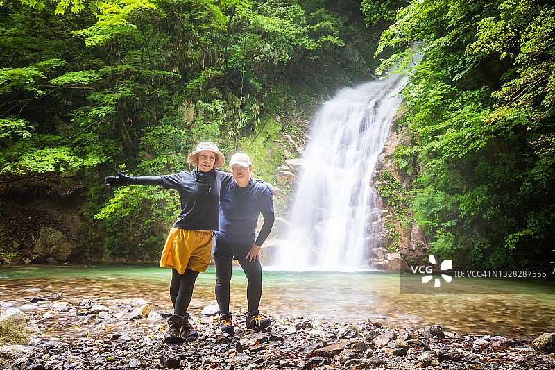 两个女徒步旅行者在大瀑布边享受大自然图片素材