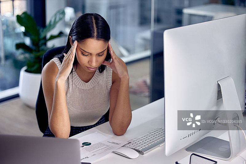 图为一位女性呼叫中心工作人员在工作时头痛图片素材