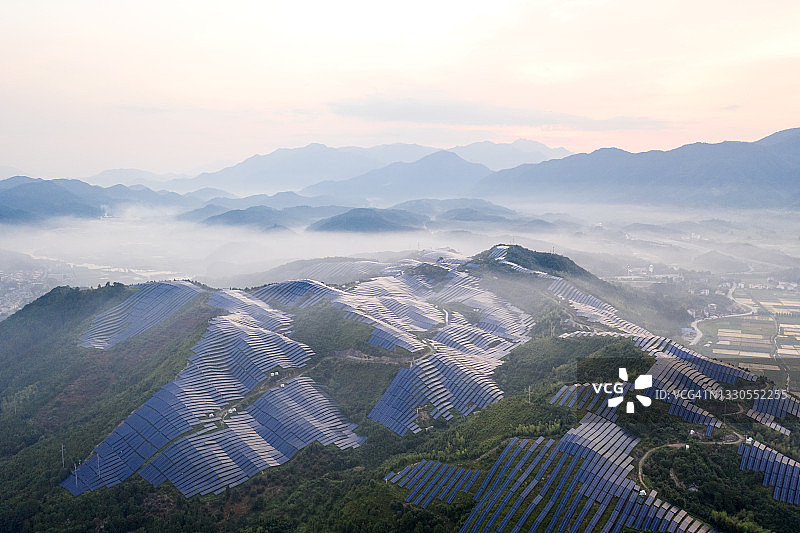 清晨，雾蒙蒙的山顶上有一座太阳能发电站图片素材