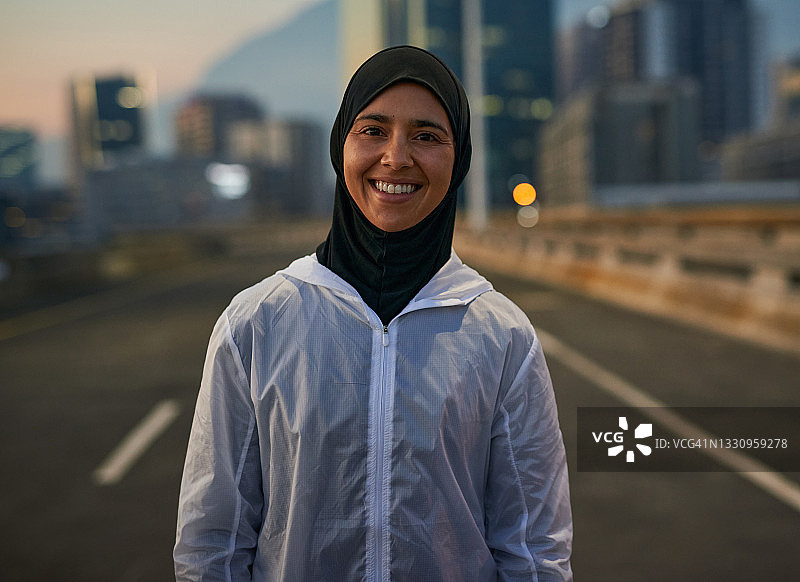 一名迷人的穆斯林女子在晨跑前独自站在城市里图片素材