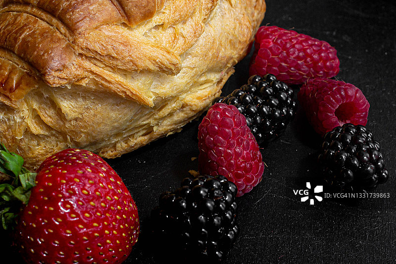 红润的羊角面包配树莓，草莓和黑莓图片素材
