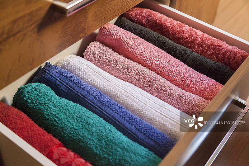 顶视图彩色毛巾存储和组织在一个木制的衣服警卫抽屉。图片素材