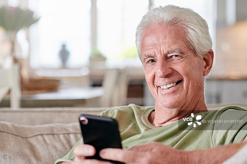 一名老人坐在家里用手机图片素材