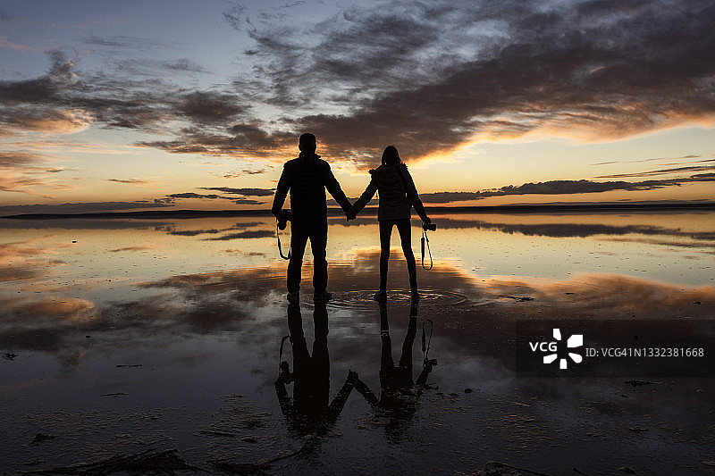 安卡拉盐湖(图兹gölü)，在美丽的天空下，相爱的情侣手牵着手看日落图片素材