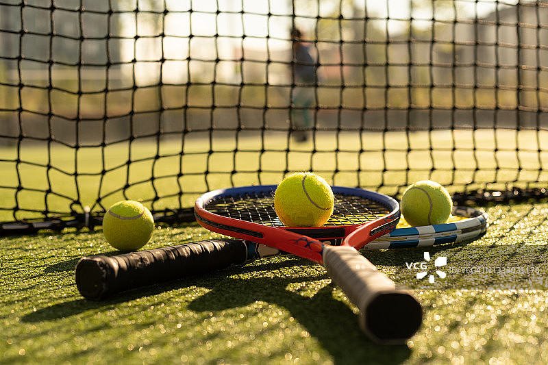 近距离观察网球场上的两个网球拍和球。图片素材