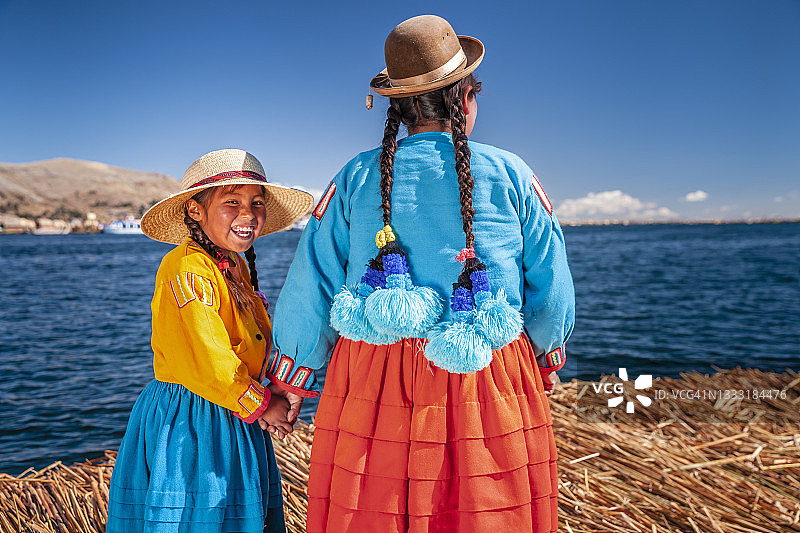 母亲和她的女儿在秘鲁的提提卡卡湖的乌洛斯浮岛上看风景图片素材