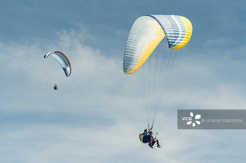 外国人滑翔伞在海洋和山脉在风车观点。普吉岛,泰国图片素材