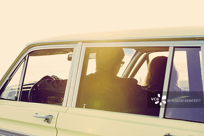 日落时分，年轻男女坐在车里图片素材