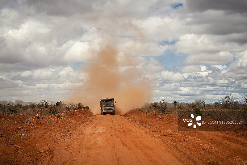 非洲肯尼亚东部国家公园，一辆越野车在扬起红尘。图片素材