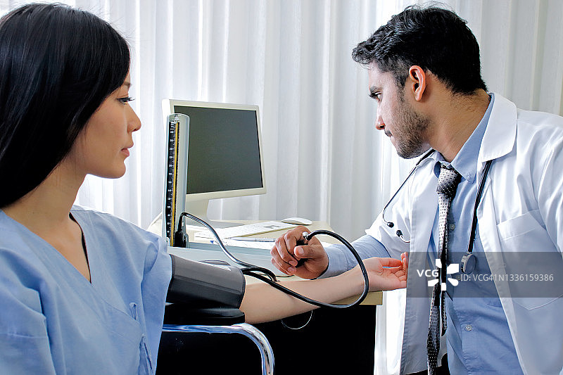 保健、医院和医学概念。医生正在测量病人的血压图片素材