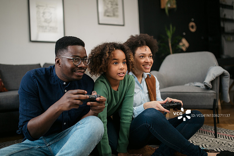 快乐的非裔美国家庭在家里玩电子游戏图片素材