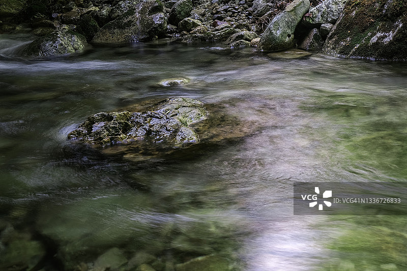 河中的岩石在缓慢流动的水中图片素材