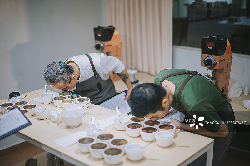 高角度视角专业亚洲华人咖啡师品级表演咖啡杯弯下腰近距离闻咖啡图片素材