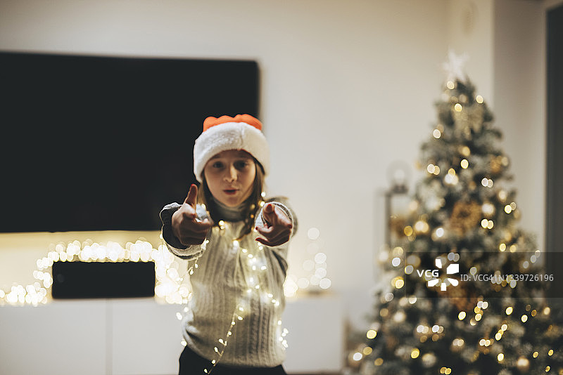 戴着圣诞帽的小女孩在平安夜跳舞图片素材