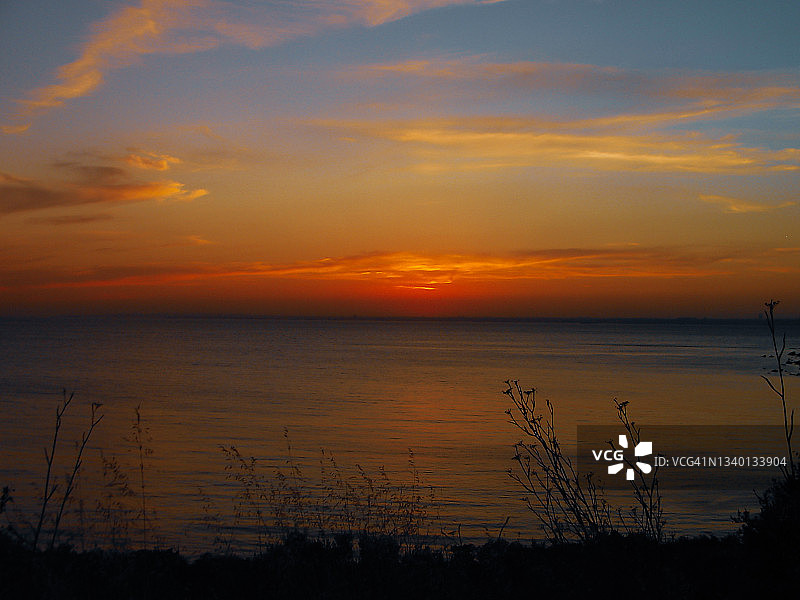 从一个岛屿上看，夕阳西下，景色绚丽多彩图片素材