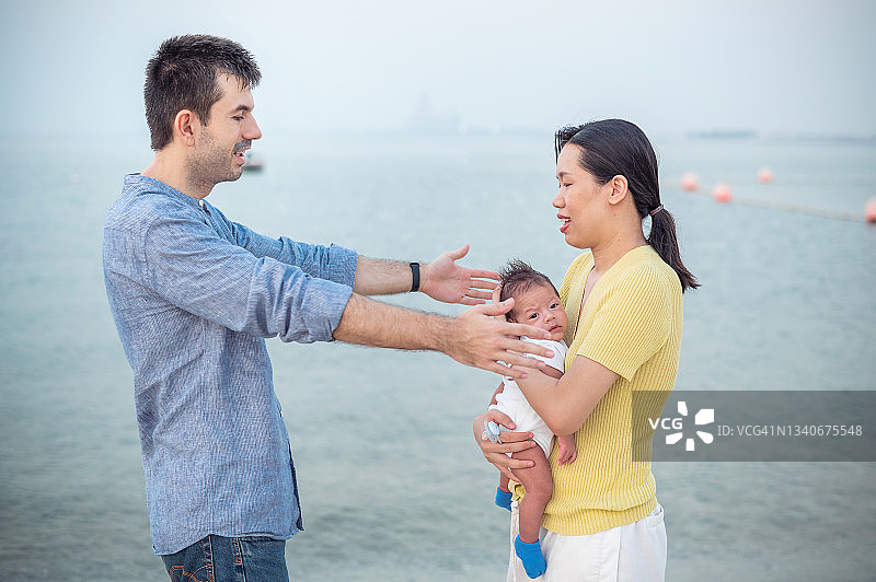 幸福的家庭和一个刚出生的婴儿在海边图片素材