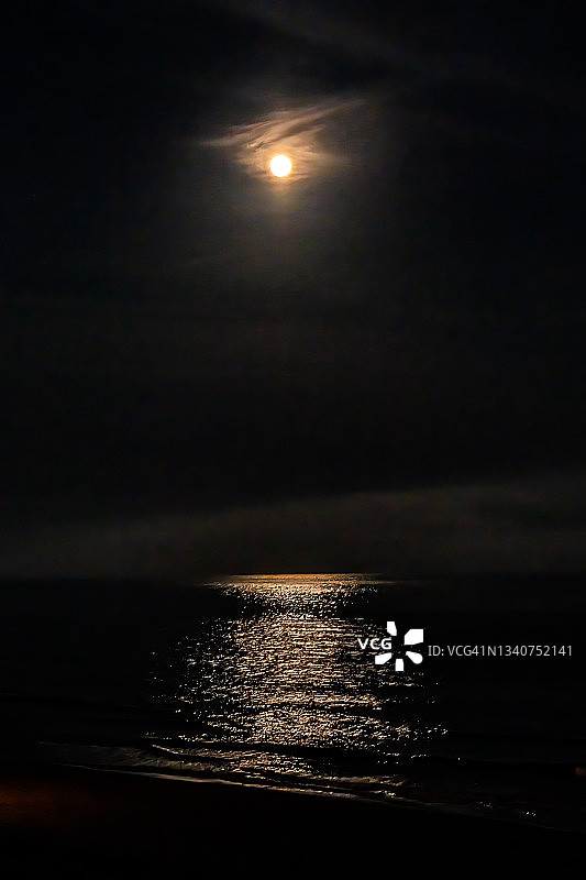 垂直视图大满月上升海面大西洋在黑暗的夜晚与月球光路径反映在水与云在默特尔比奇，南卡罗莱纳图片素材