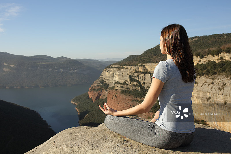 一个女人在悬崖顶上做瑜伽图片素材