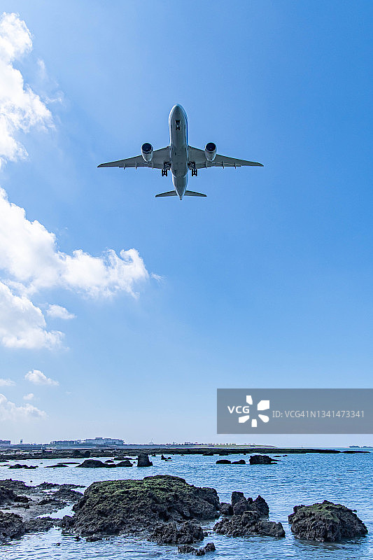 飞机飞过日本冲绳的珊瑚海滩图片素材