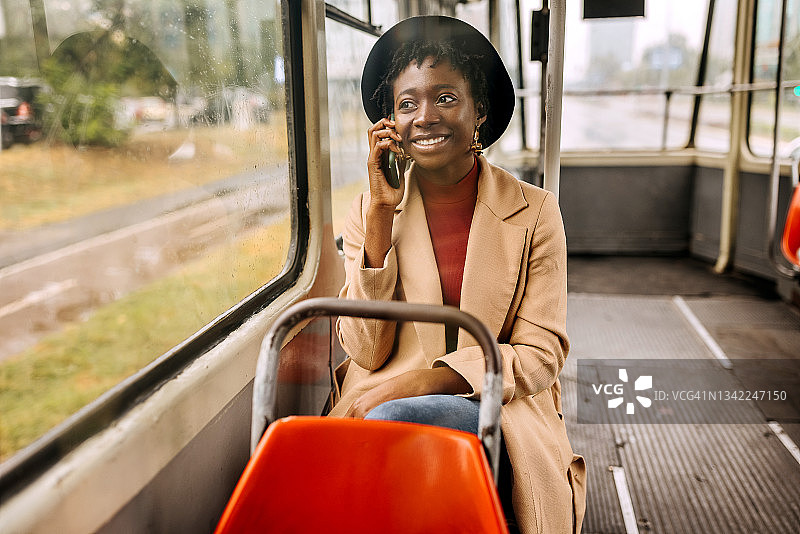 年轻女子乘巴士旅行，还打电话图片素材