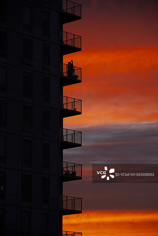 公寓大楼与夫妇在阳台日落，渥太华，安大略省，加拿大图片素材