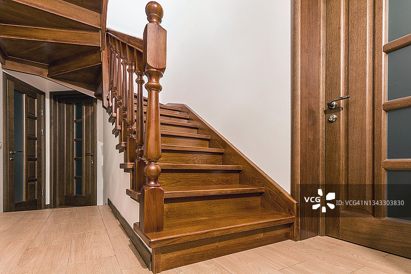 现代棕色橡木楼梯和门在新装修的房子内部图片素材