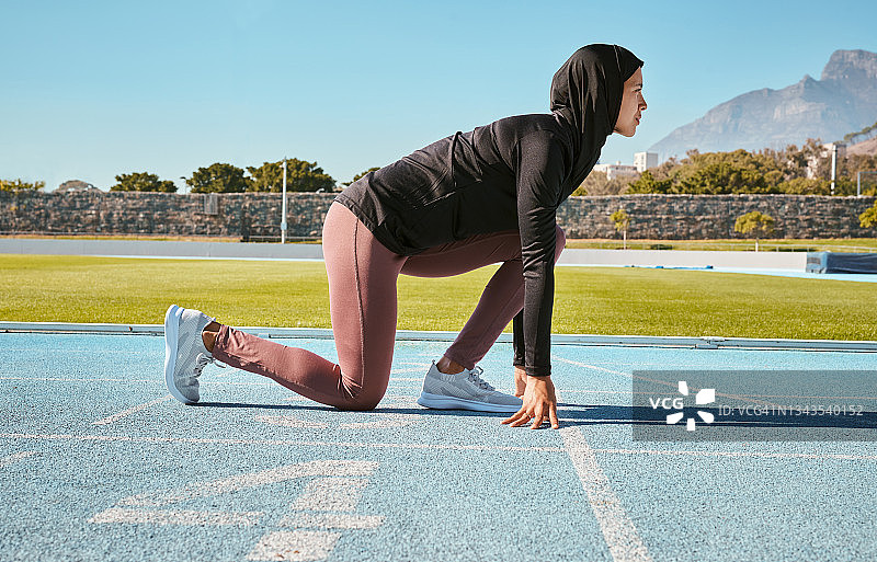 一名年轻女子戴着头巾在跑道上训练图片素材