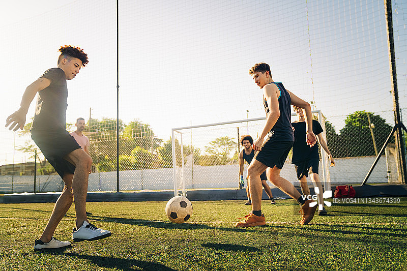 男运动员在阳光明媚的日子里踢足球图片素材
