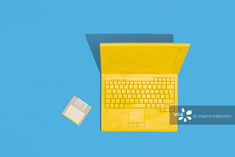 蓝色背景的黄色笔记本电脑和软盘图片素材