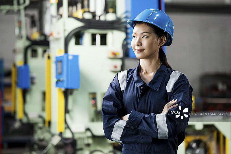 智能产业制造工程师。一幅女性工业工程师的肖像，她站在一台压力机前，看着生产线上的其他地方。她有控制生产计划的技能。图片素材