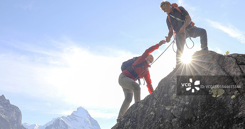 登山夫妇在攀登瑞士阿尔卑斯山的岩壁图片素材