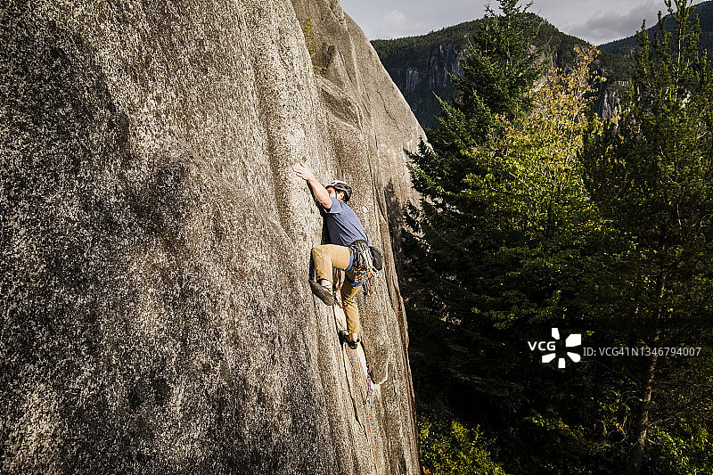 在不列颠哥伦比亚省斯夸米什，一块男子岩石爬上了一块空白而困难的岩石表面图片素材