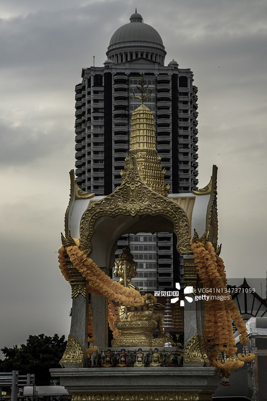 四面佛金像，以高层现代建筑为背景。图片素材