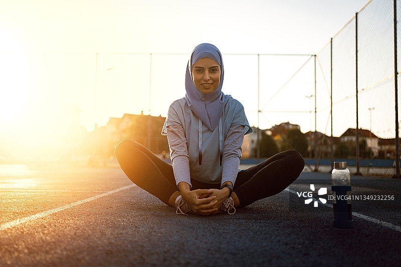 满意的穆斯林女运动员伸展身体的肖像图片素材