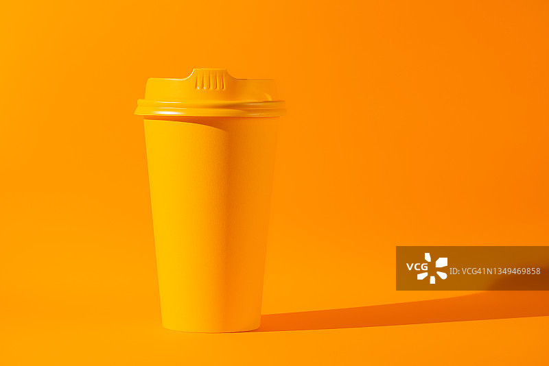 橙色背景下的黄色咖啡杯图片素材